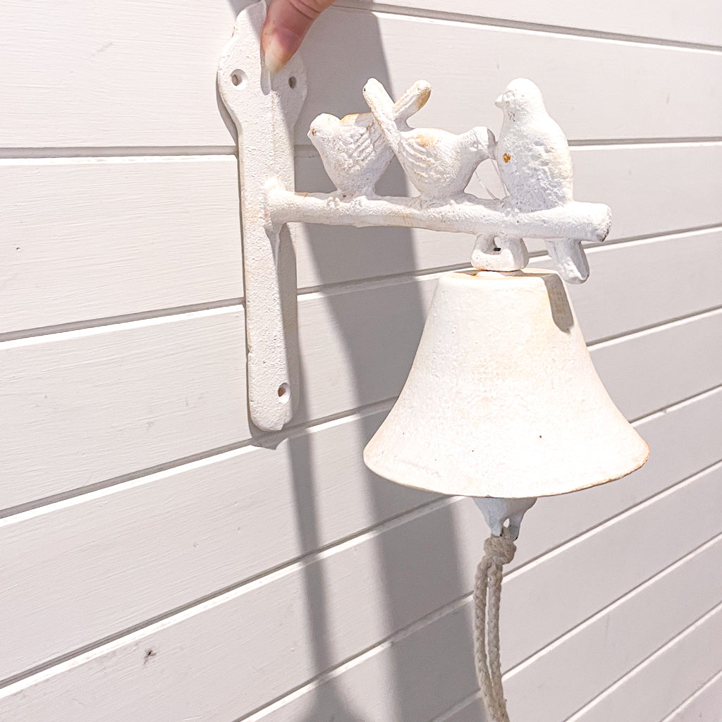 White washed antique style door bell with birds