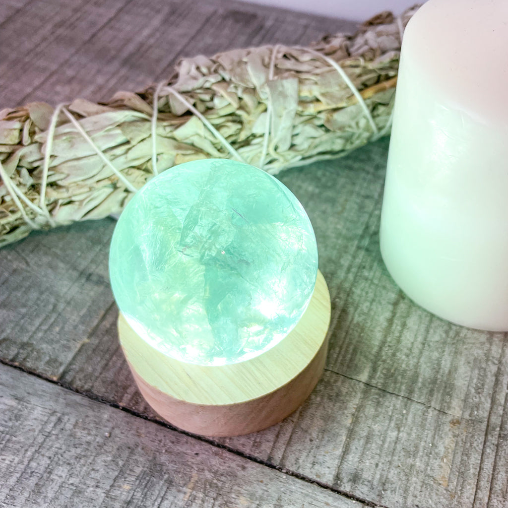 Fluorite green crystal polished sphere with rainbow inclusions