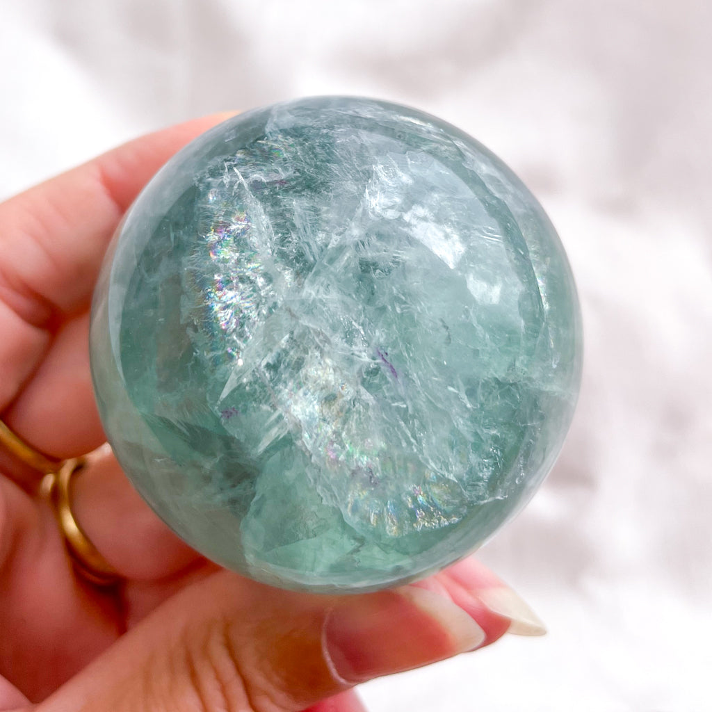 Fluorite green crystal polished sphere with rainbow inclusions