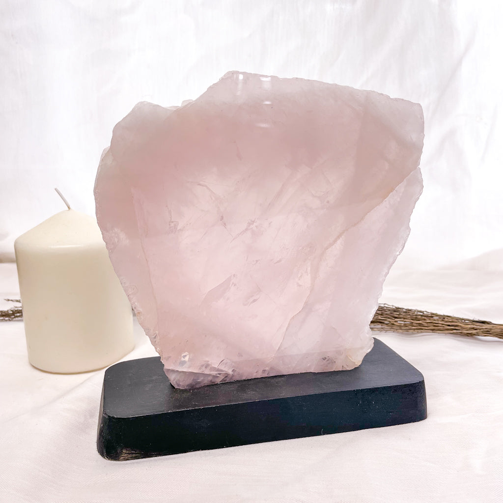 Rose quartz crystal polished slab on black stand