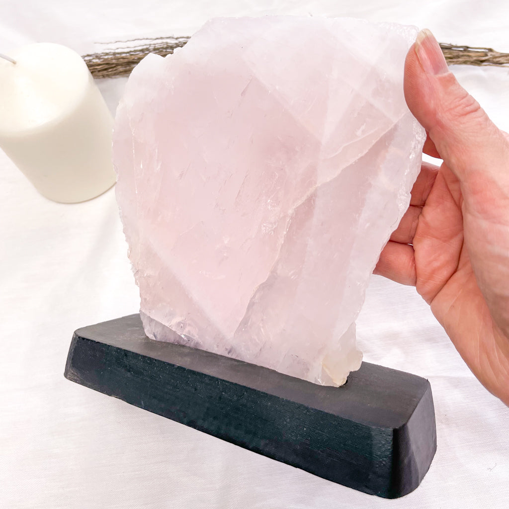 Rose quartz crystal polished slab on black stand